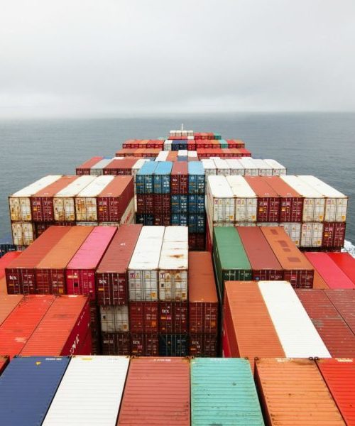 picture of shipping vessel being loaded with containers by cranes at port